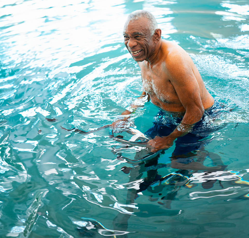 A senior man floats in a swimming pool