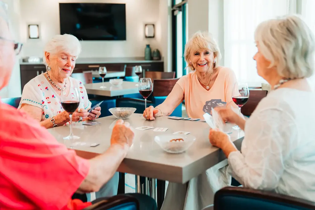 A group of senior adults play a round of cards at a dining table