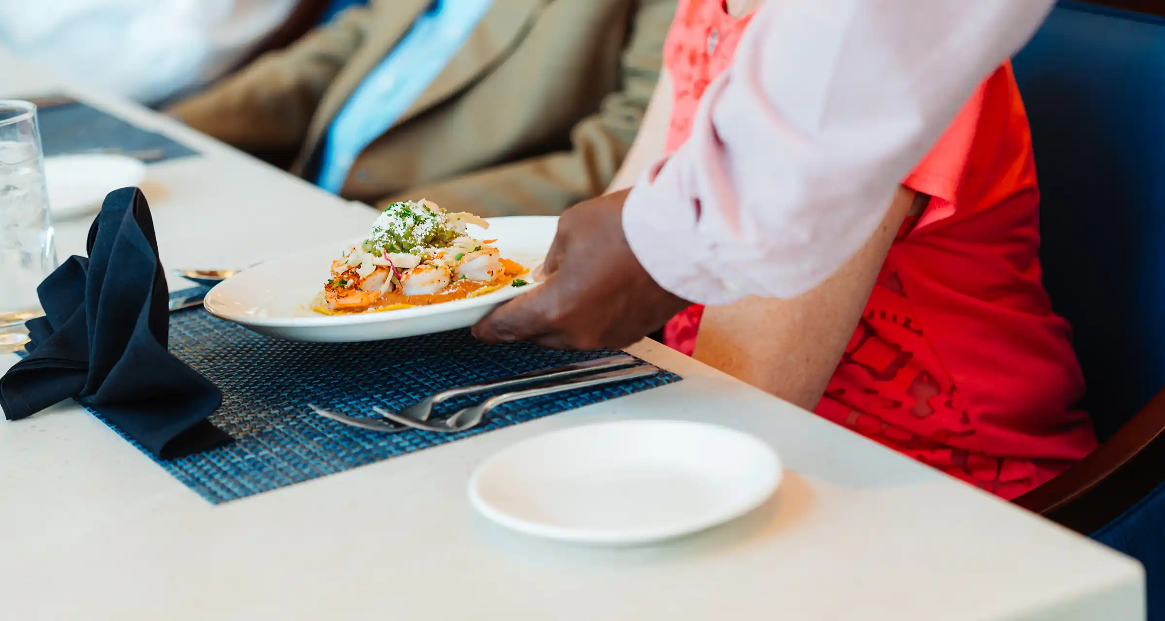 A plate of food is served on a cloth-covered dining room table in a restaurant setting