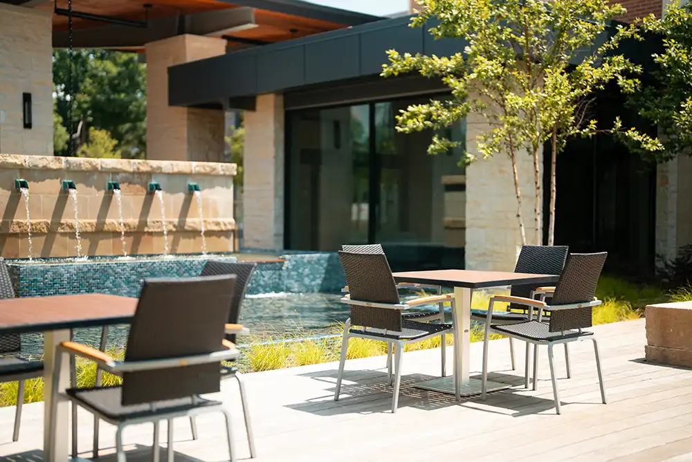 An outdoor table seating space near a water feature