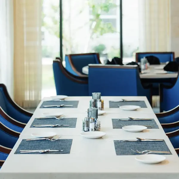 A white-linen dining table in a restaurant environment featuring natural lighting