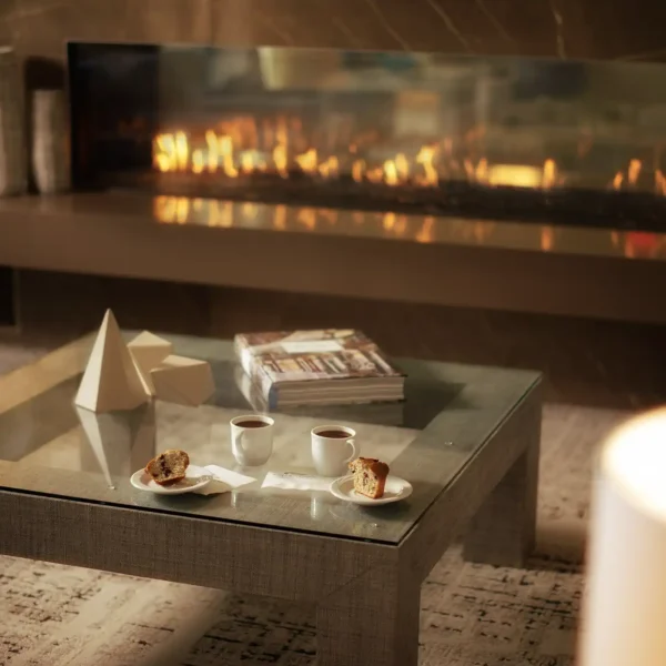 A modern coffee table with a pair of coffee cups near a fireplace