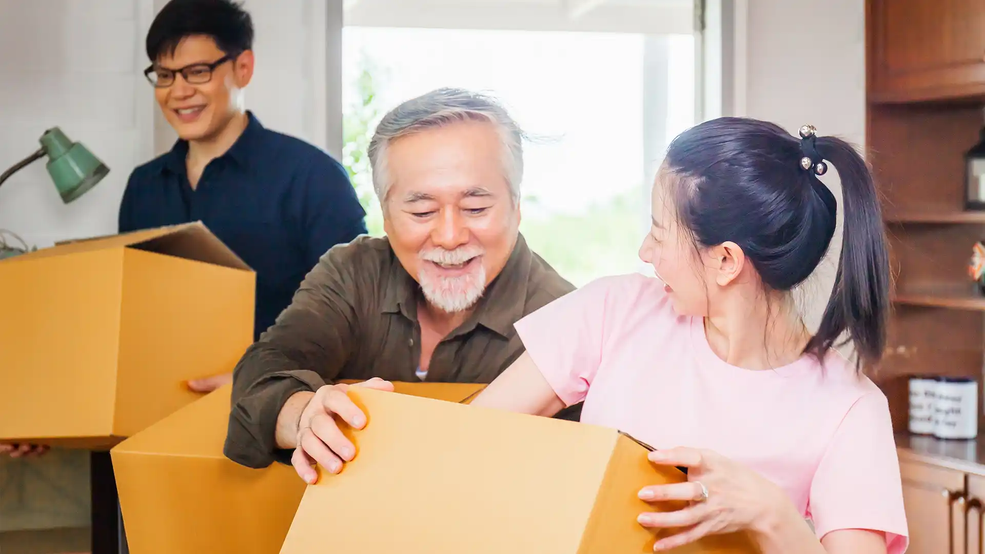 Senior man and adult children moving boxes