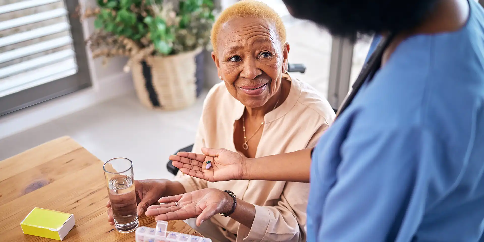 Nurse assisting with senior with medication.